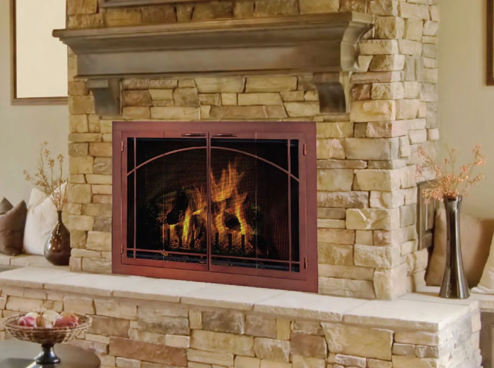 Decorative fireplace doors on a stone masonry fireplace