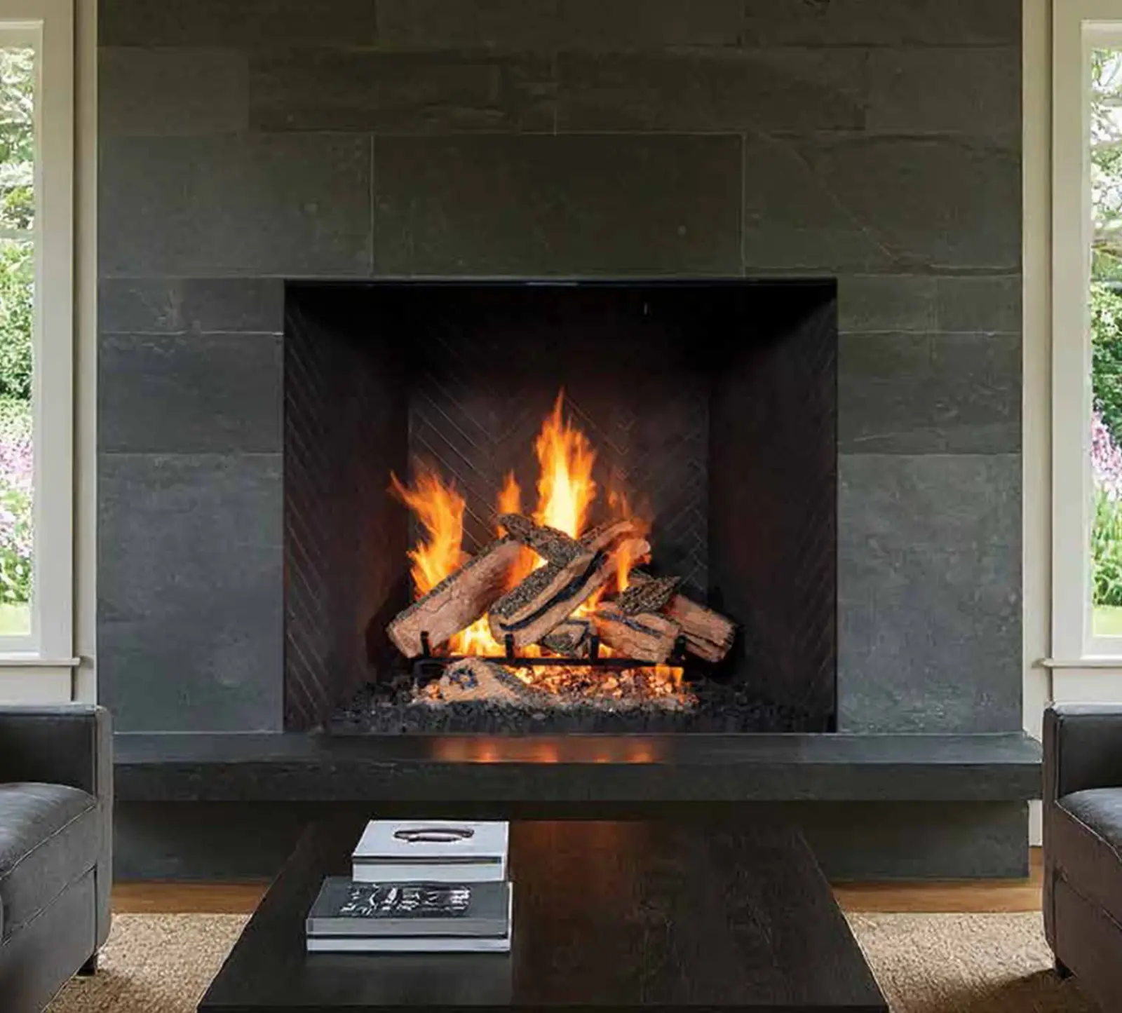 Open-front fireplace with burning gas logs and a dark stone surround