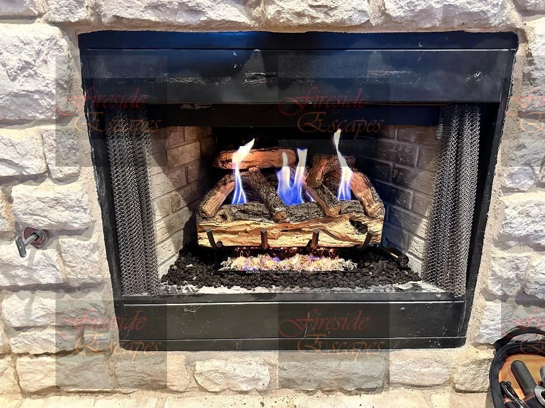 Gas logs burning in a stone fireplace