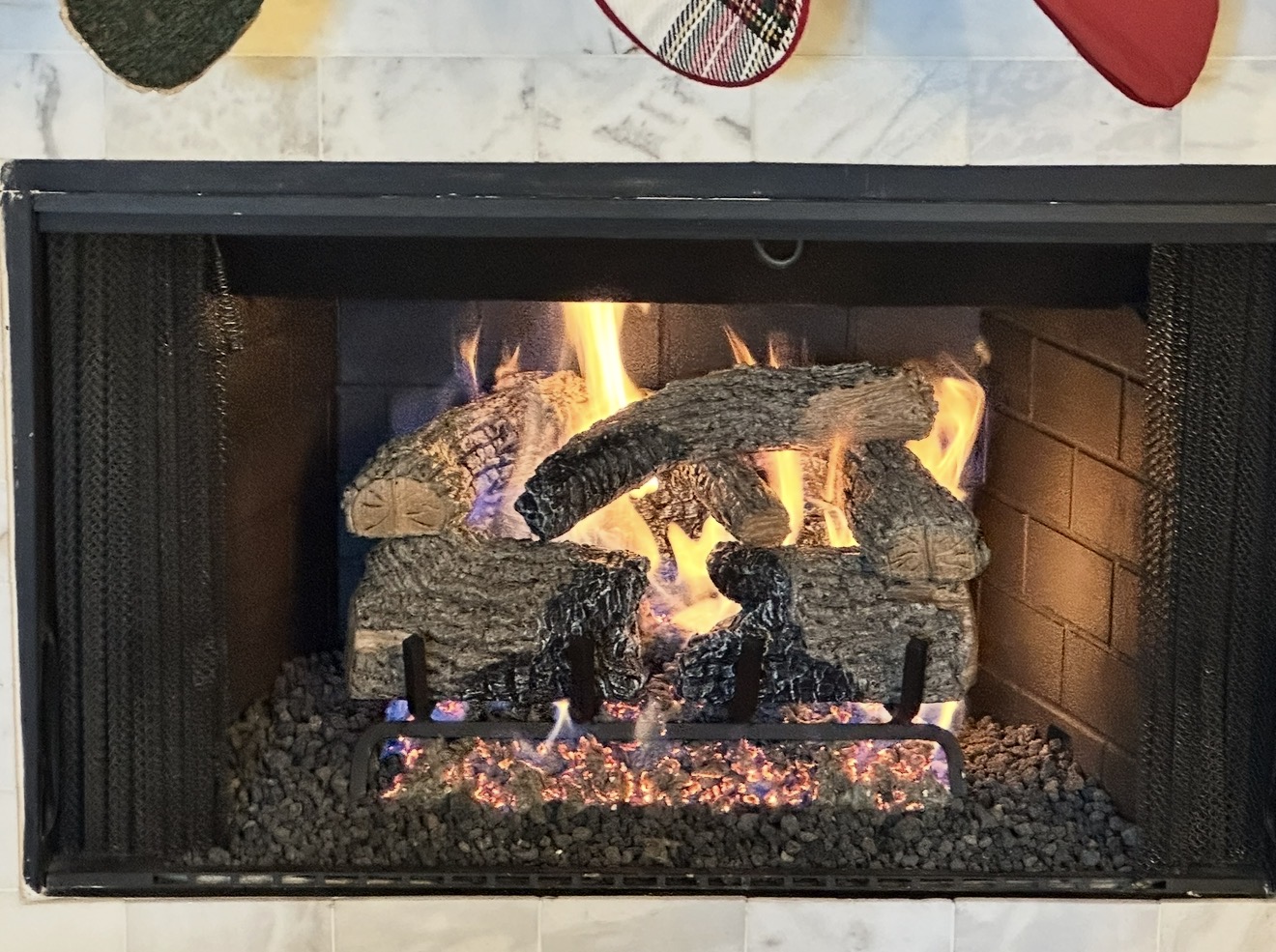 Gas log set installed by Fireside Escapes burning inside a fireplace in McKinney, Texas